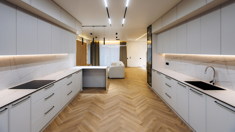 A wide, ultra-modern galley kitchen with under-cabinet lighting
