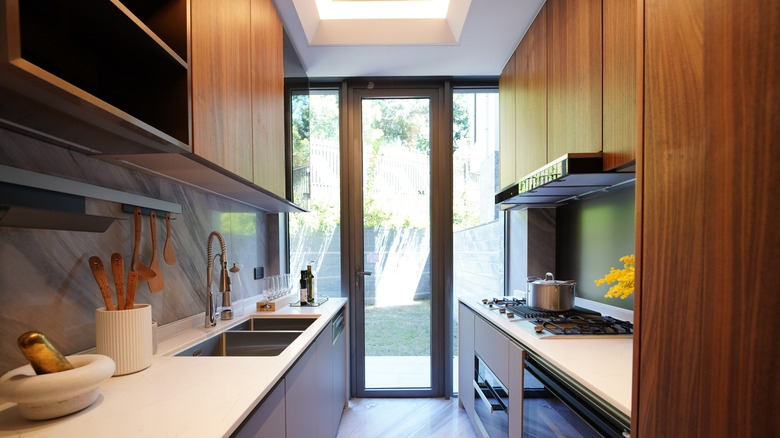 Contemporary galley kitchen with a large glass door at the end