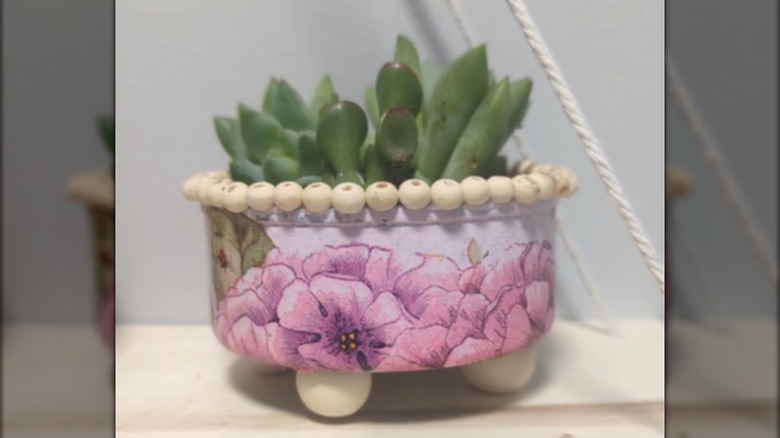 A decorated tuna can becomes a succulent planter.