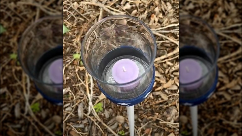 A tuna can attached to a post and sunk into the ground is a cheap way to make a candle torch.