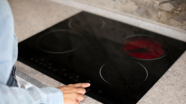 A glass stove with one of the burner rings still hot