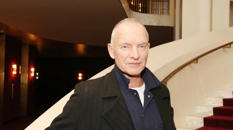 Sting standing on stairs at a performance venues