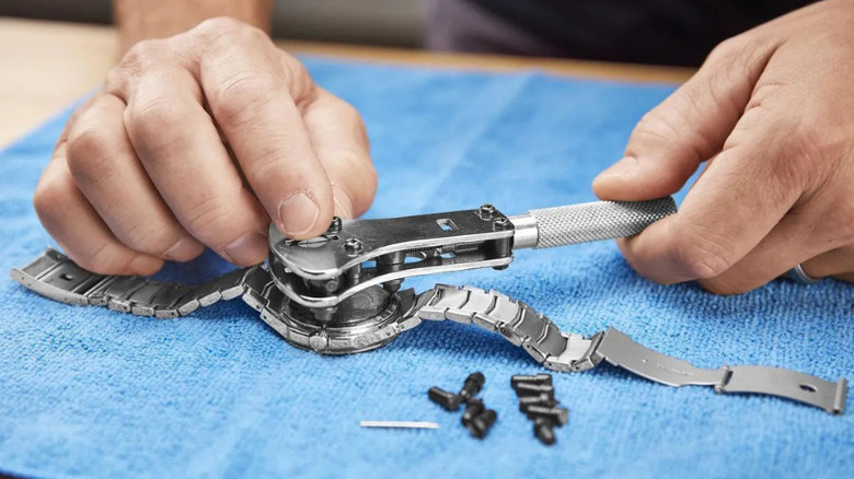 Close-up of a person using the Watch Case Opener from Pittsburgh