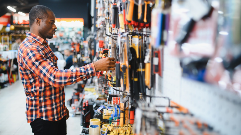 A man choosing tools in a hardware store