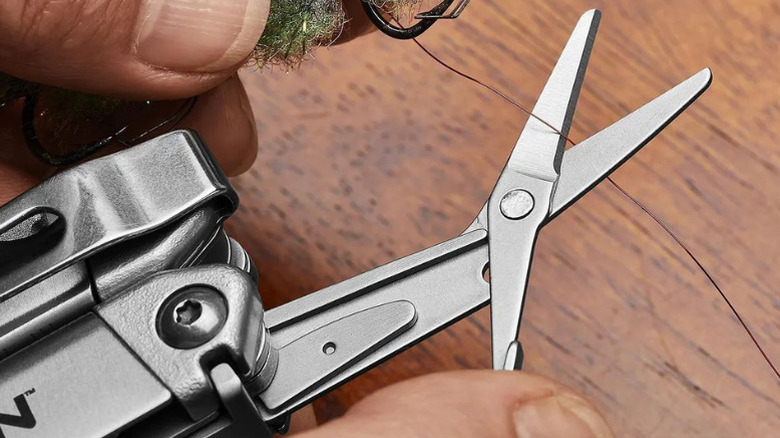 A person cutting fishing line with Gordon's 20-in-1 Multi Tool
