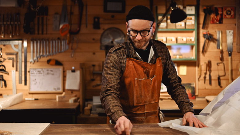 A man working at a workbench in a garage or workshop