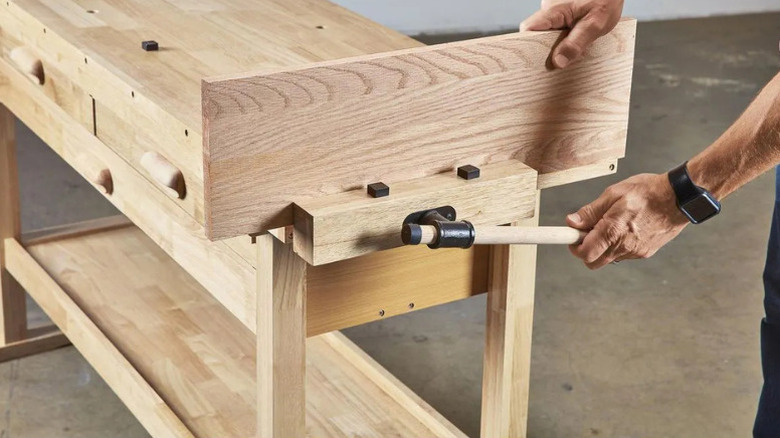 A man using the wood vise on Yukon's 6 in. 3-Drawer Hardwood Workbench
