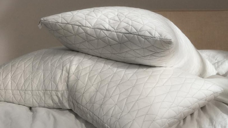 Two white pillows sans cover on a bed