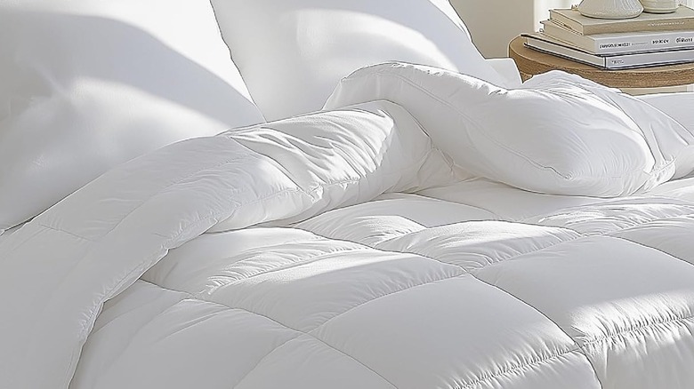 A white duvet insert spread out on a bed