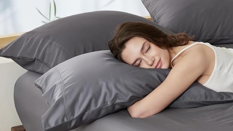 Woman sleeping on a pillow covered in a gray cover
