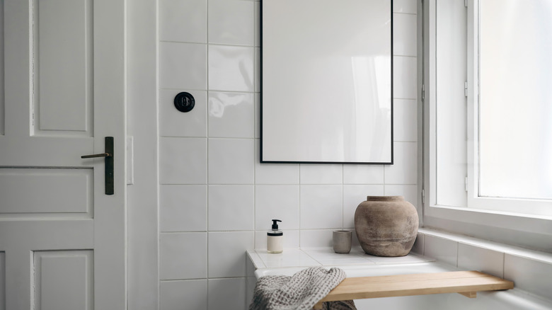 black picture frame on wall above bathtub