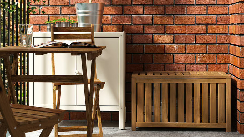 The NÄMMARÖ acacia storage box in an outdoor patio setting