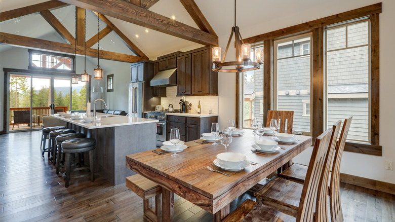 Dining room near modern and rustic luxury kitchen with vaulted ceiling and wooden beams