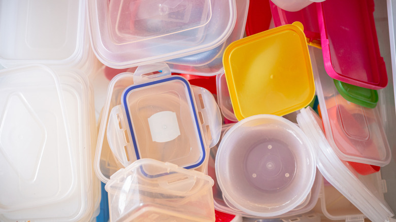 A stack of plastic food containers and lids