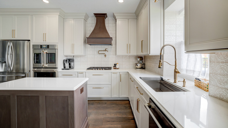 White cabinets in a kitchen touching the ceiling