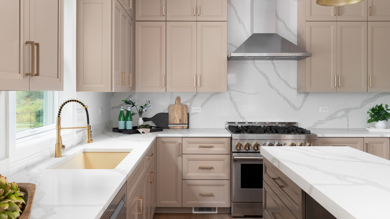 A kitchen with marble island, backsplash, and counter