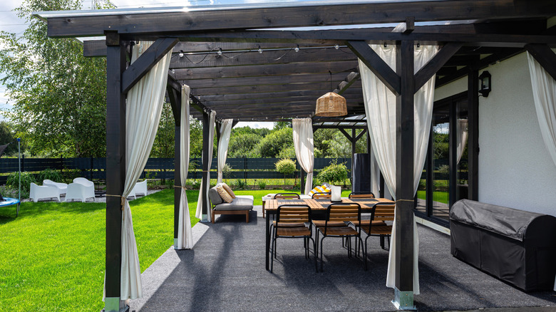 A pergola with white curtains