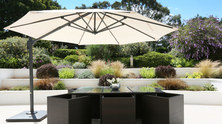 A patio seating area shaded by a cantilevered parasol