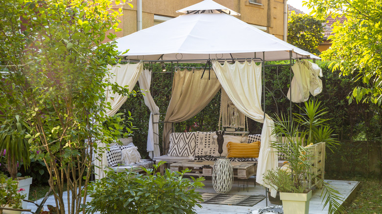 A cozy gazebo in a garden surrounded by plantings