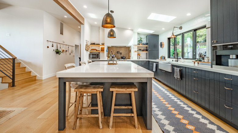 A bright, modern kitchen with a very large island and open shelves