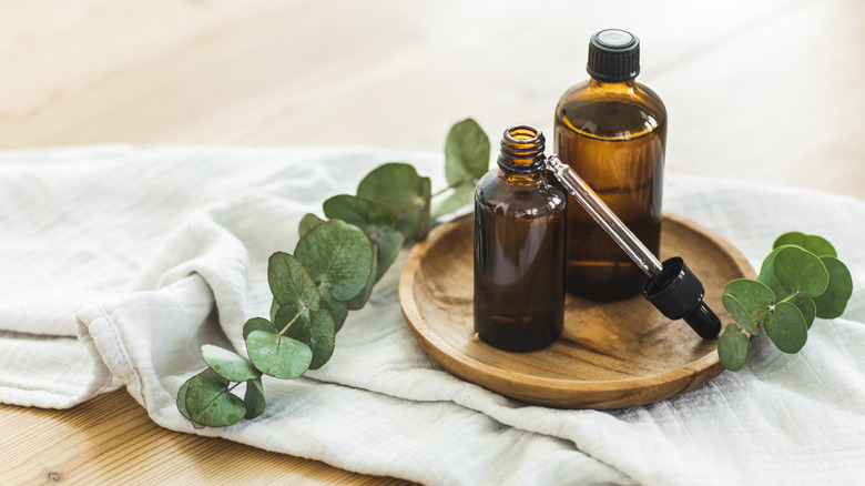 Two bottles of unlabeled essential oils on cloth placed on the floor