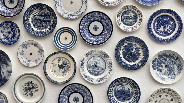 Blue patterned plates hang on a wall