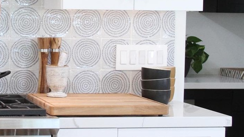 A tile backsplash with a circular pattern