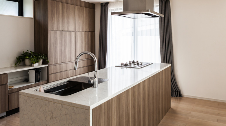 A large kitchen island with integrated sink and stove