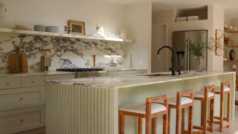 A kitchen featuring a marble island and backsplash.
