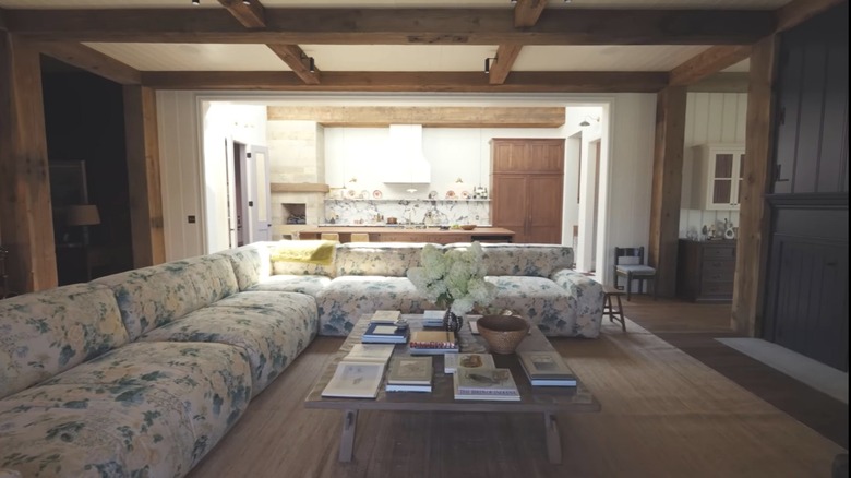 A living room with a floral L-shape couch