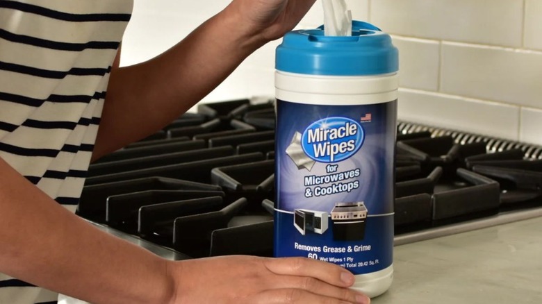 Individual uses Miracle Wipes on the front of an oven