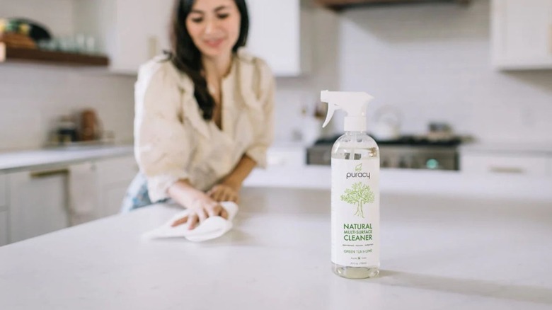 Woman using Puracy cleaner on a counter