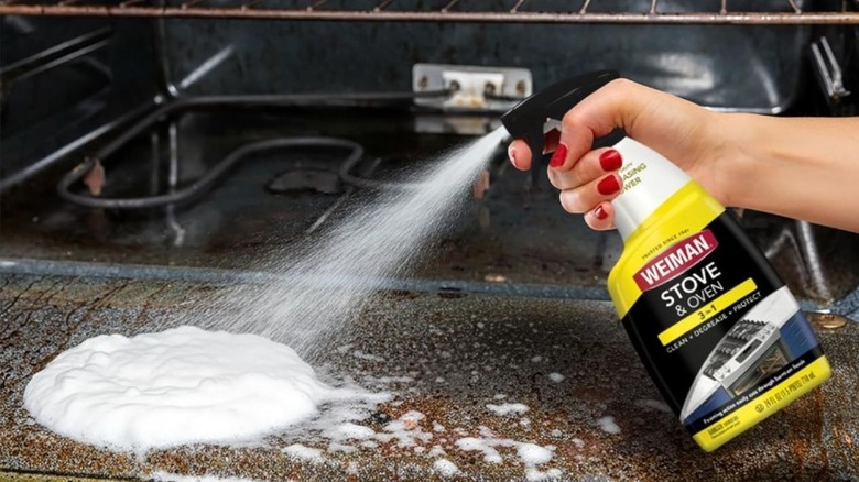 Individual spraying Weiman cleaner on an oven door