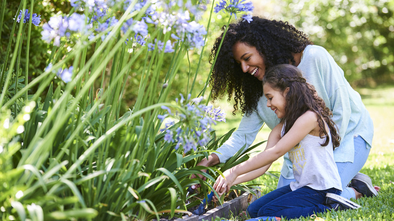 Gardener and daughter tending a garden