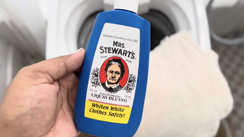 Woman holds a bottle of Mrs. Stewarts laundry bluing