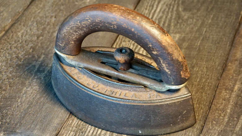 Sad iron with a wooden handle on a table