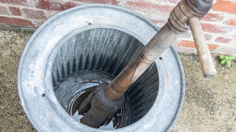 Vintage wooden washing dolly in a metal tub