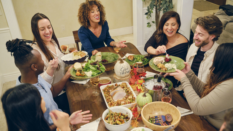 Group of people smiling and eating at a table