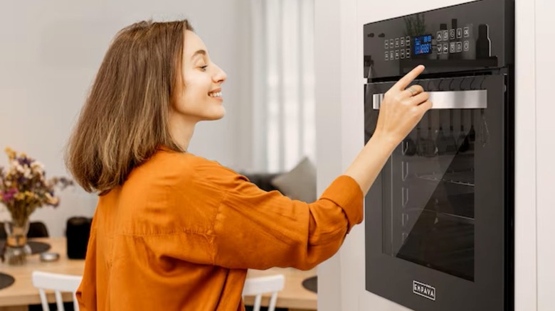 A person touching the controls on a wall over