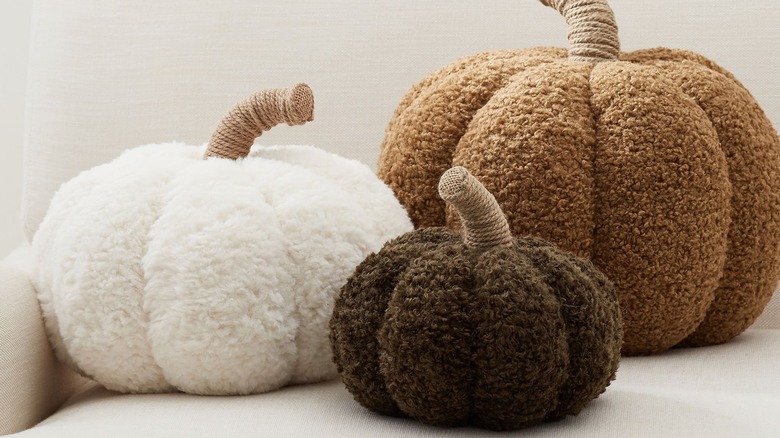 Pumpkin-shaped pillows on a couch