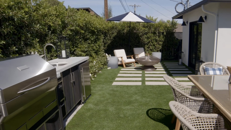 Black cedar fence covered by a hedge