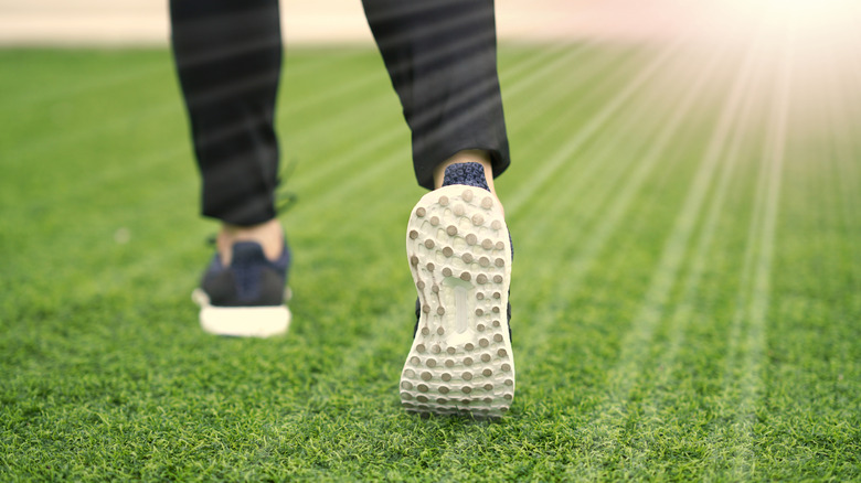 Person's feet walking on artificial turf