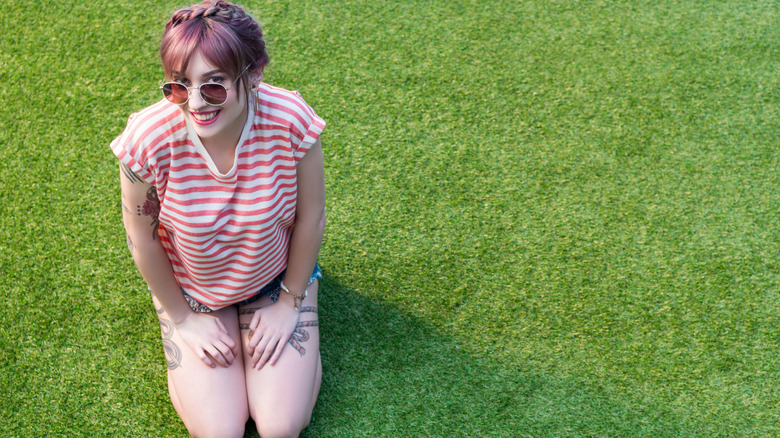 Happy woman sitting on artificial turf