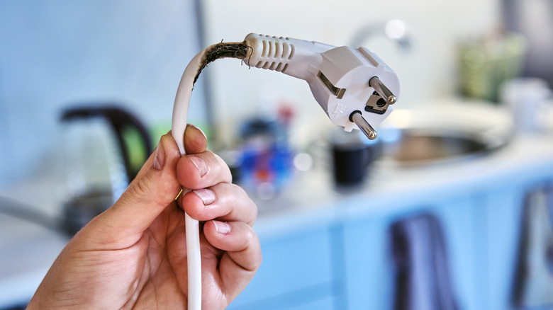 An electrical appliance cord with signs of burn damage
