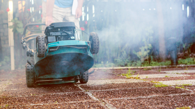 A lawn mower giving off plumes of smoke