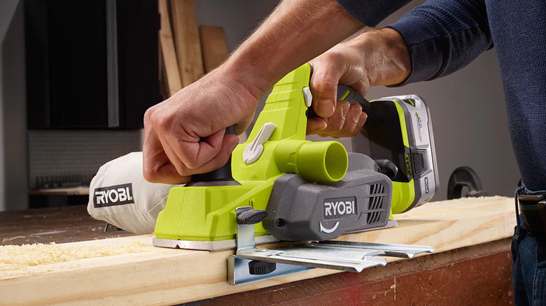 A person using Ryobi's 18V One+ Planer on a piece of wood