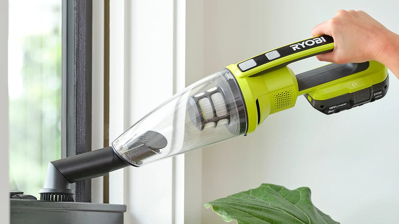 A person cleaning with Ryobi's 18V One+ cordless performance handheld vacuum kit