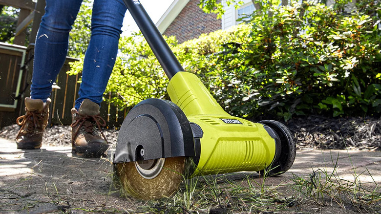 Close-up showing Ryobi's 18V One+ patio cleaner with wire brush edger in action
