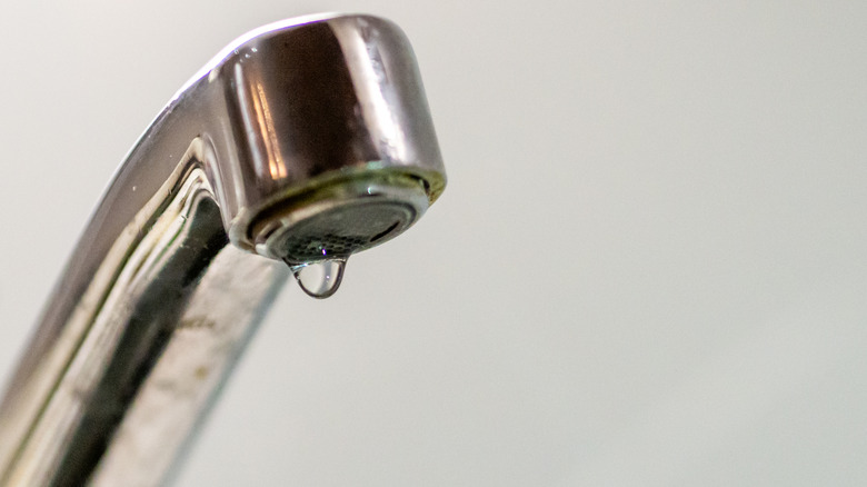 A silver faucet dripping