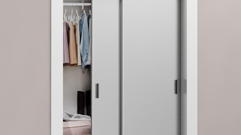 Black edge fingerpull door handles are installed on grey sliding closet doors